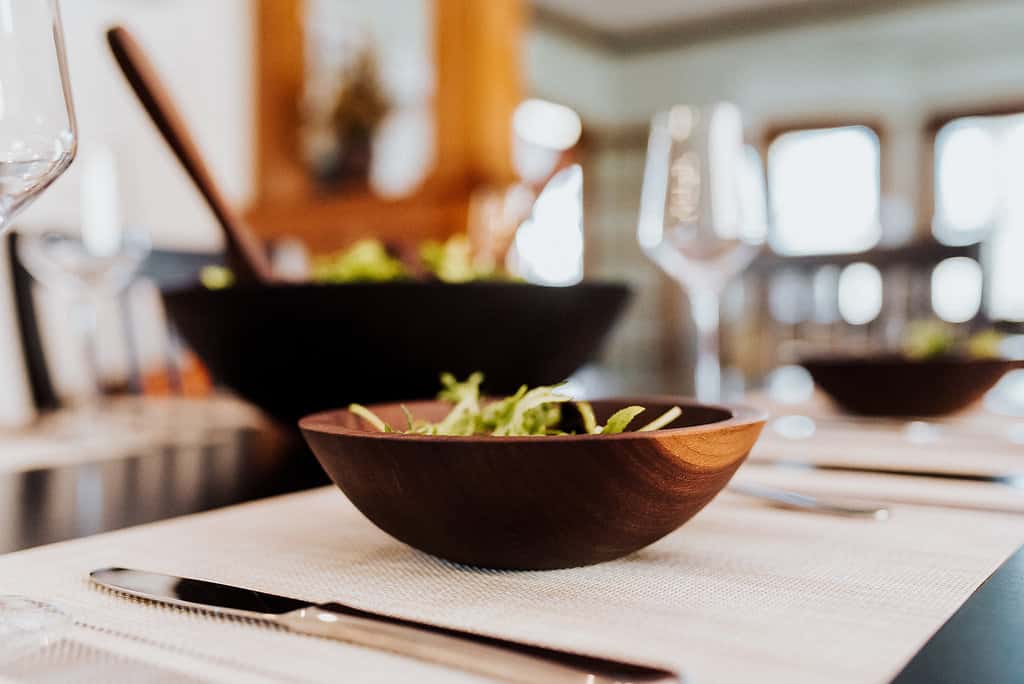 A dining room table set with wooden salad bowls. The Holland Bowl Mill received results when they asked us to build positive reviews.